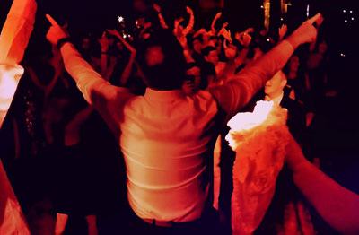 Photo of a man putting his hands in the air to a song played by DJ Nick Arkell